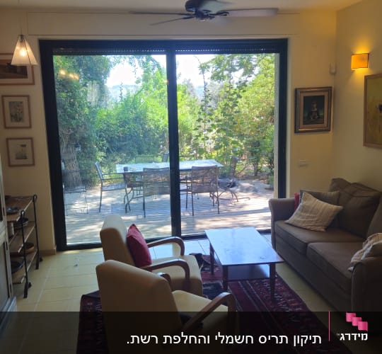 סלון עם חלון גדול ונוף לגינה